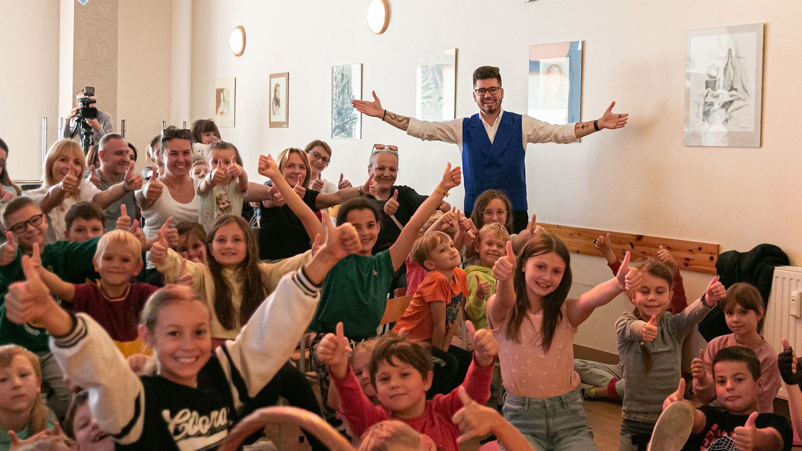 Armand Górny z uśmiechniętymi dziećmi i rodzicami po wspólnym pokazie magii